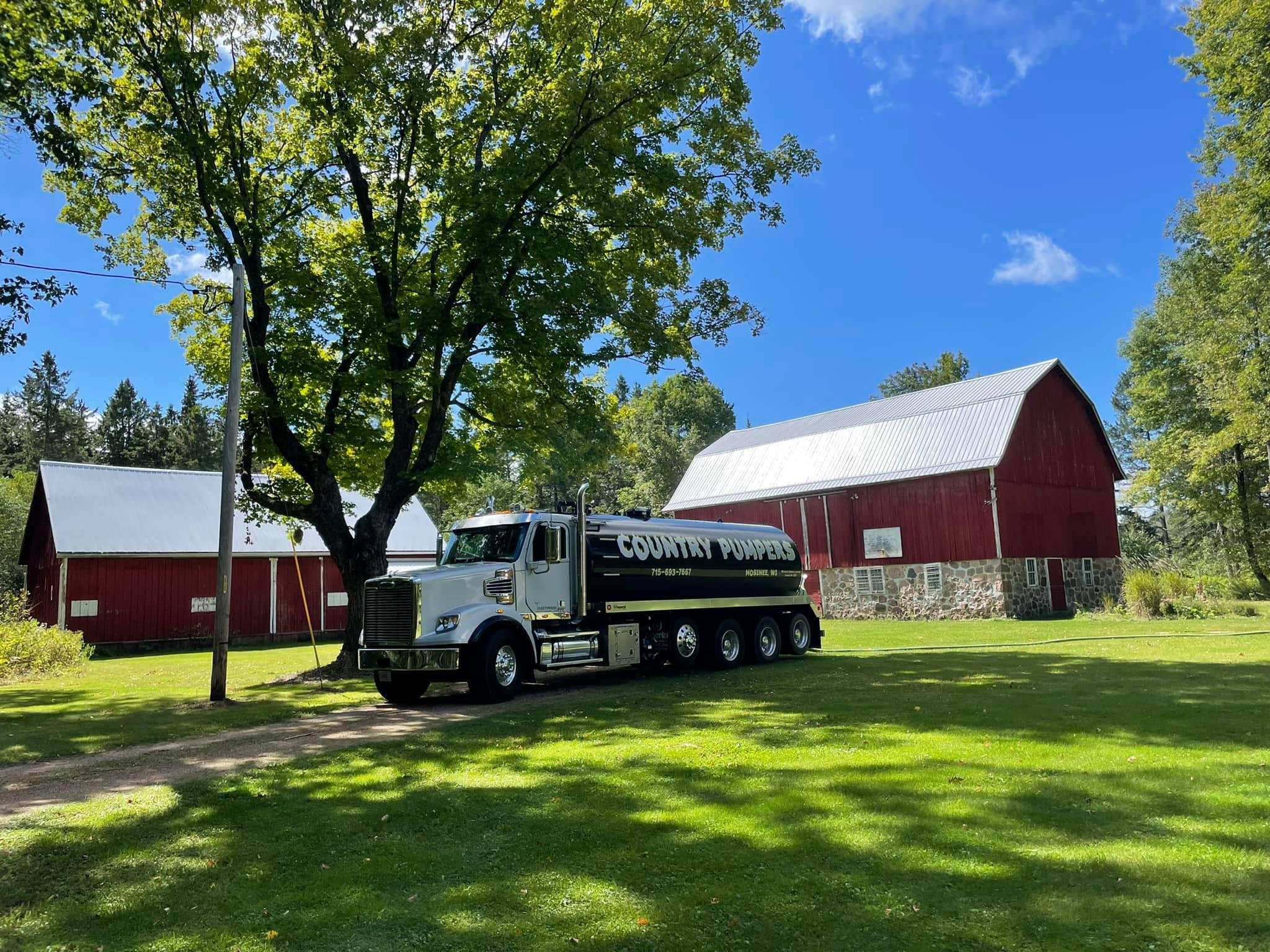 Country Pumpers truck near two barns